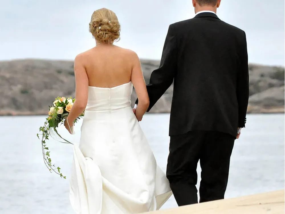 Nygift par på klippor vid havet i Heestrand – bröllopsplats i Bohusläns skärgård