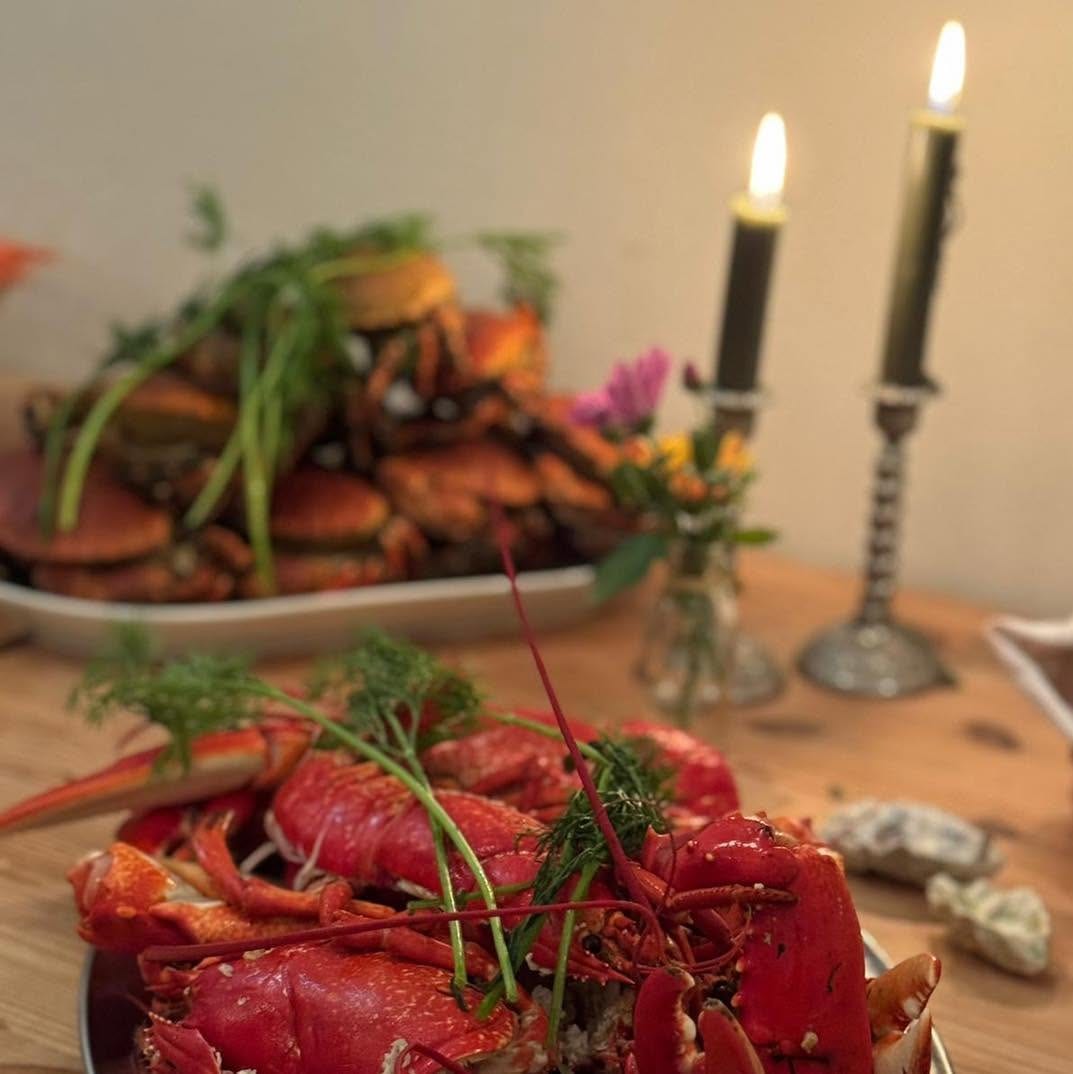 Hummer och krabba på fat vid levande ljus